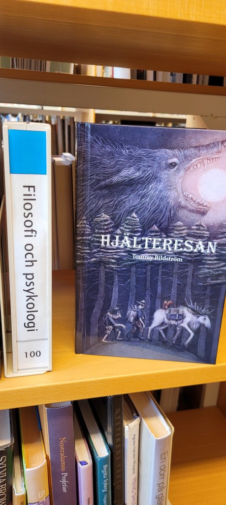 Boken Hjälteresan på en bibliotekshylla med en skylt med texten Filosofi och psykologi intill.